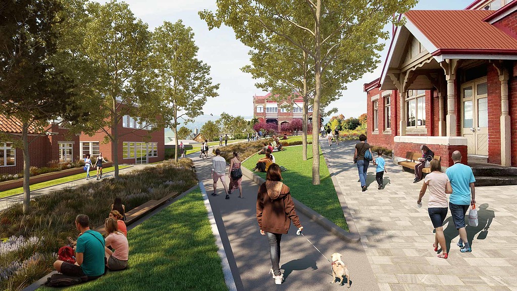 A group of people walking on a path between buildings.